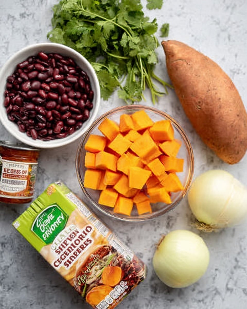 The image shows a white marble surface with ingredients neatly arranged. There is a small white bowl filled with dark red beans at the top left, fresh green cilantro leaves placed beside it, and a whole sweet potato to the top right. Below them is a clear white bowl with large orange sweet potato cubes. A cut yellow onion with visible layers sits near the bottom right corner, and a carton of organic vegetable broth with green and orange labeling is positioned at the bottom left. A small can of chipotle peppers in adobo sauce with red and white labeling is placed near the center. photo taken with an iphone --ar 4:5 --v 7