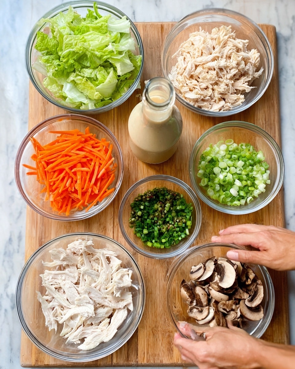 The image displays eight glass bowls arranged on a wooden cutting board placed on a white marbled surface. Starting from the top left, there is a bowl filled with chopped green lettuce with a fresh, leafy texture. To its right, a bowl contains shredded pale beige chicken. Below the lettuce bowl is a bowl of thin, bright orange carrot sticks arranged uniformly. In the middle, a clear glass bottle with a beige liquid, likely dressing, stands tall. To the right of the bottle is a small bowl filled with finely chopped green onions. Below the carrots is a bowl of finely chopped dark green herbs. At the bottom right, a bowl holds slices of brown mushrooms with a soft texture. The largest bowl at the bottom center contains shredded white chicken pieces. A woman's hand is lightly touching the wood surface near the bowls. Photo taken with an iphone --ar 4:5 --v 7