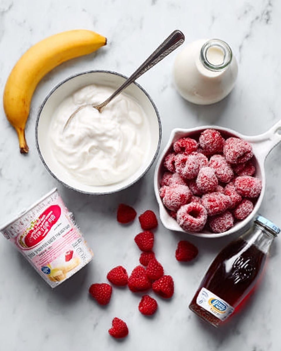 A white marbled surface holds several items arranged neatly: a small white bowl filled with thick white yogurt and a metal spoon inside, a white saucepan filled with frozen red raspberries and some scattered raspberries nearby, a peeled banana resting on the surface, a small clear bottle of dark syrup, a glass bottle of milk, and a container of strawberry-flavored yogurt with a mostly pink and white label. The colors focus on white, red, and yellow tones with a clean, bright look. photo taken with an iphone --ar 4:5 --v 7