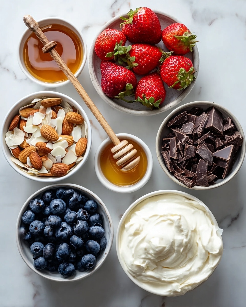 The image shows six round white bowls arranged in a circle on a white marbled surface, each filled with different ingredients. One bowl holds whole strawberries and sliced strawberries, bright red with green leaves. Another bowl contains dark blue blueberries with a smooth texture. A third bowl is filled with light brown sliced almonds mixed with whole almonds. The fourth bowl has dark brown chopped chocolate pieces with rough edges. There is a small white bowl with golden honey and a wooden honey dipper resting inside it. The last bowl contains creamy, thick white yogurt with soft folds. Photo taken with an iphone --ar 4:5 --v 7