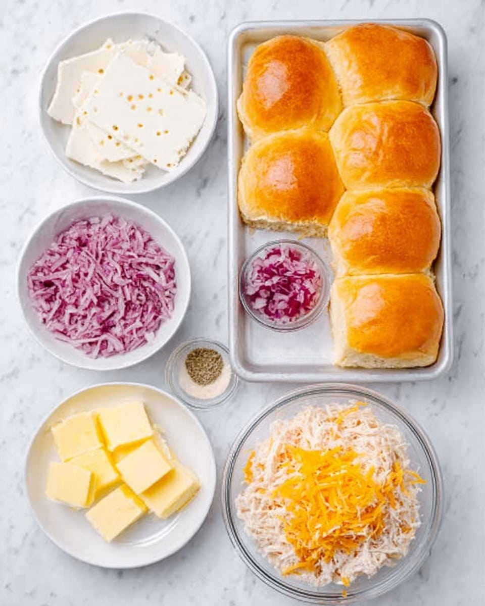 The image shows a white marbled surface with four white dishes and one clear dish arranged above a baking pan filled with 12 soft orange dinner rolls. The top left white dish holds several slices of white cheese with small holes. Below it, a smaller white bowl contains finely chopped red onions. To the right is a larger white bowl starting with a base of shredded chicken topped with white shredded cheese. A clear glass bowl with pepper sits near the chopped onions. On the bottom left, a plain round white dish contains several pats of yellow butter. The rolls in the pan are close together, showing a smooth, shiny top texture photo taken with an iphone --ar 4:5 --v 7