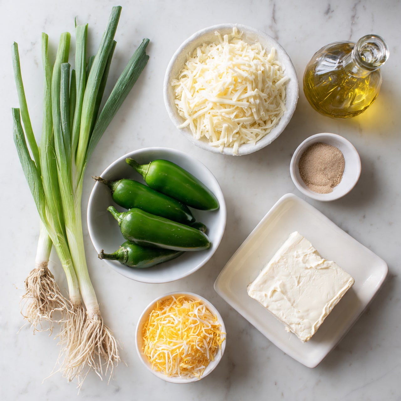 The image shows fresh green jalapeño peppers in a white bowl placed slightly to the left center on a white marbled surface. To the right of the peppers, there are three small white bowls arranged in a triangle: one at the top filled with shredded white cheese, one in the middle with a light tan powder, and one at the bottom containing shredded yellow cheese. Below these, there is a white oval dish holding a large block of cream cheese. To the left side of the jalapeños, two fresh green spring onions with roots attached lay flat on the white marbled surface. Near the top right corner, there is a clear glass bottle filled with yellow oil, reflecting light gently. The overall look is clean and fresh, with bright light enhancing the vibrant green and white tones. photo taken with an iphone --ar 4:5 --v 7