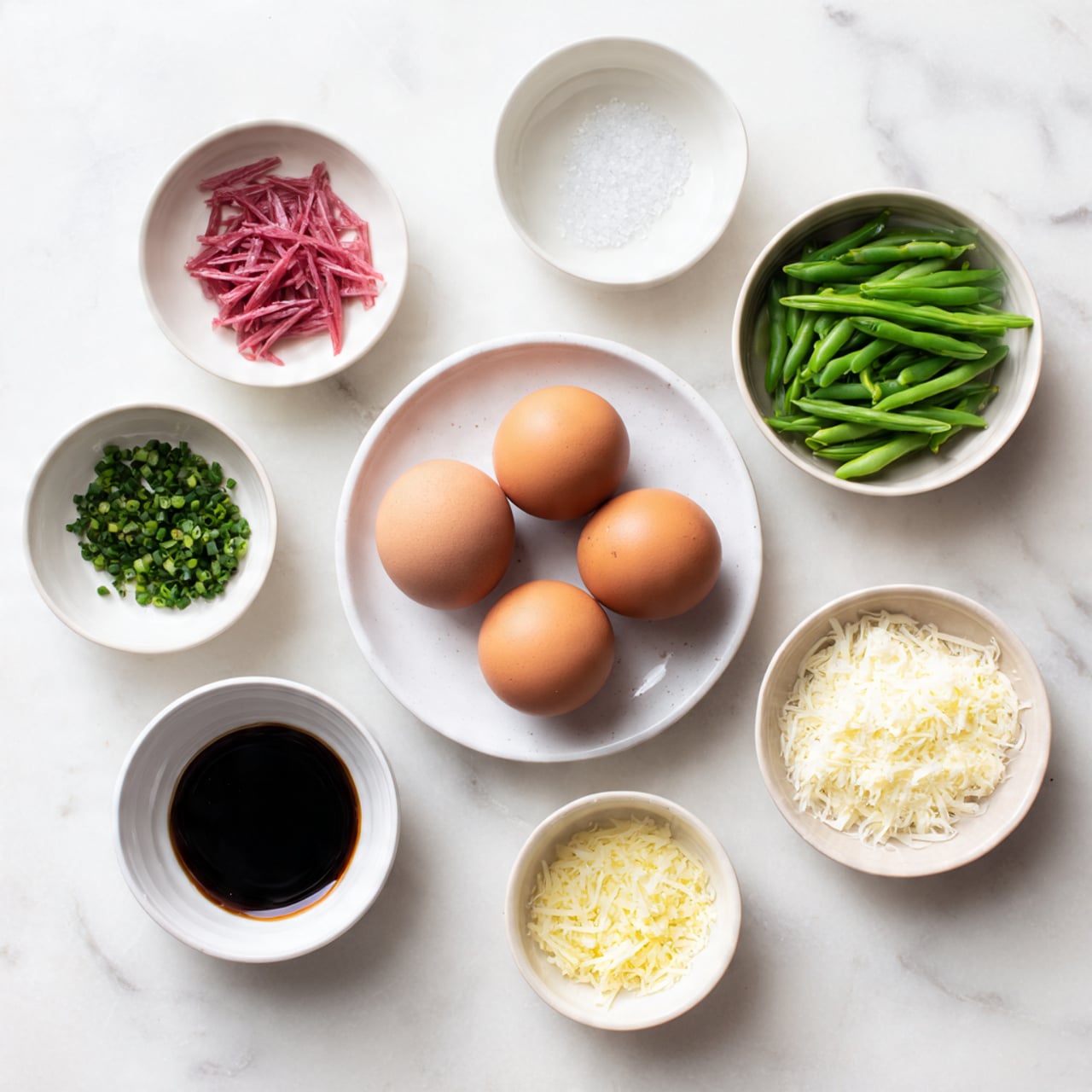 The image shows a white marbled surface with seven small white bowls and one white plate arranged neatly. In the center, a white plate holds four brown eggs. Surrounding it are six small white bowls, each containing different ingredients: something pink and thinly sliced in the top left, a few sugar crystals in the top middle, bright green snap peas in the top right, chopped green herbs at the bottom left, dark soy sauce in the bottom middle, and finely grated white cheese at the bottom right. The colors vary from soft pink, white, green, dark brown to light yellow, all placed cleanly against the white marbled background. Photo taken with an iphone --ar 4:5 --v 7