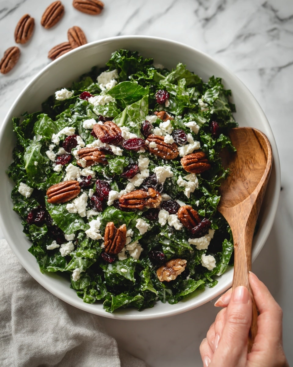 A white bowl filled with a fresh green salad consisting of chopped kale leaves as the base layer, topped with small pieces of white cheese scattered across, dark red dried cranberries, and whole pecans adding texture and color contrast. The salad looks fresh and colorful, sitting on a white marbled surface. A woman's hand holding a wooden spoon is on the right side of the bowl. Photo taken with an iphone --ar 4:5 --v 7